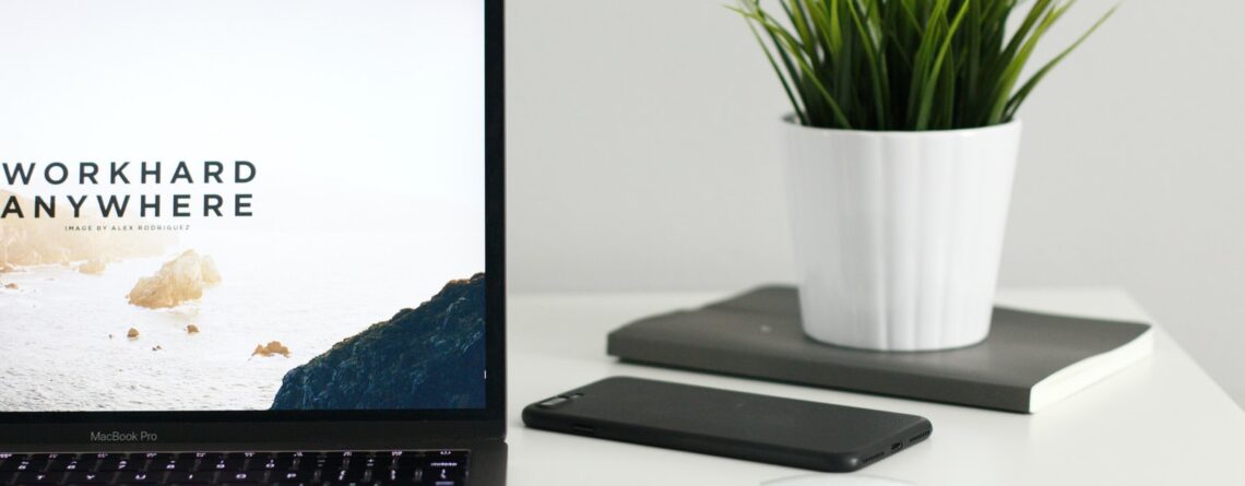 MacBook Pro near green potted plant on table