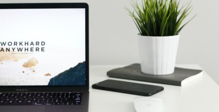 MacBook Pro near green potted plant on table